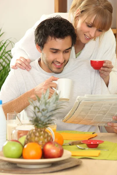 Couple reading the newspaper over breakfast — Stock Photo, Image