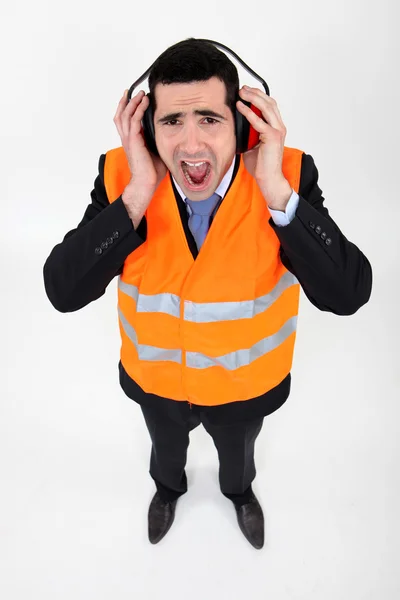 Man covering his ears with earmuffs — Stock Photo, Image