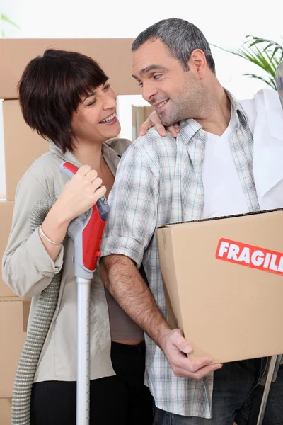 Casal se mudando para nova casa com caixas marcadas frágeis — Fotografia de Stock