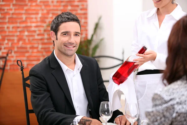 Garçonete trazendo vinho ao cliente — Fotografia de Stock