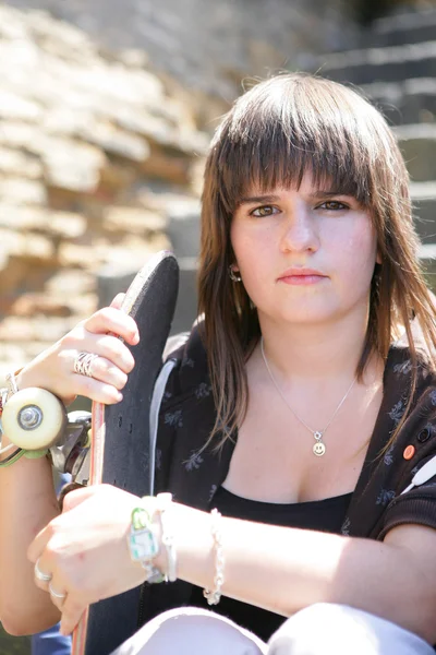 A teenage girl holding a skateboard — Stock Photo, Image