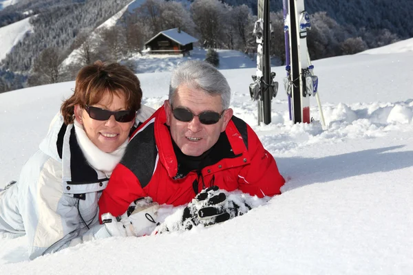 Paar liegt im Schnee — Stockfoto