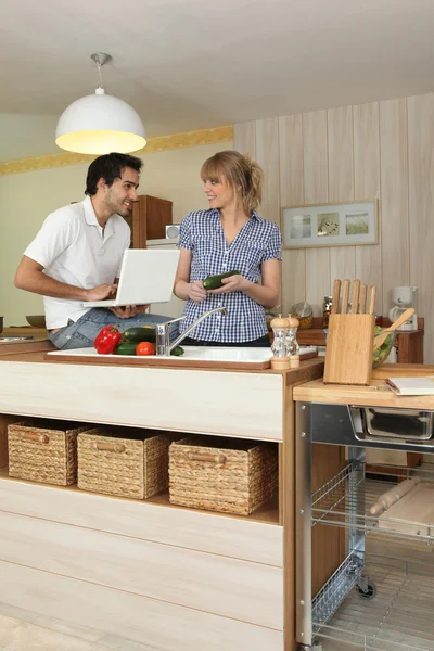 Genç adam ve genç kadın mutfakta gülümseyen — Stok fotoğraf