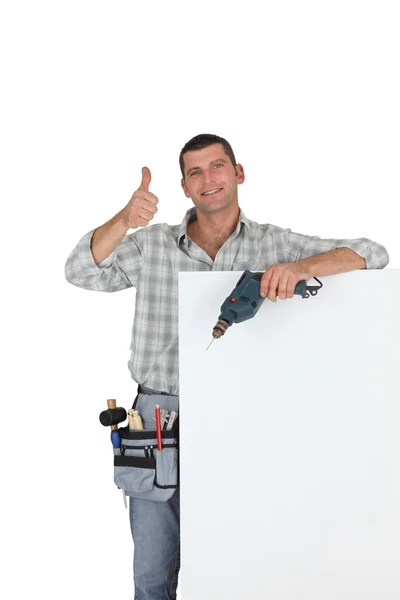 Thumbs up van een bouwer met een leeg bord — Stockfoto