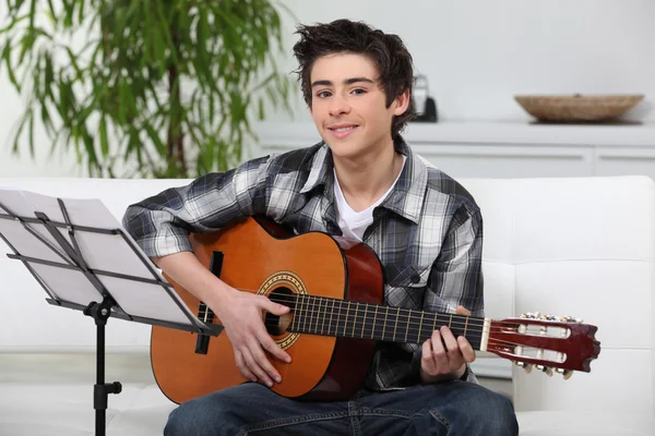 En ung pojke lärande gitarr. — Stockfoto