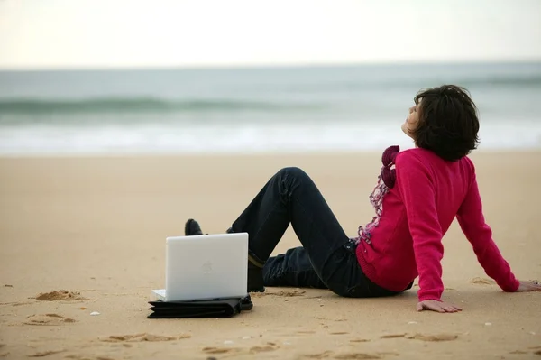 Mulher em uma praia com seu laptop — Fotografia de Stock