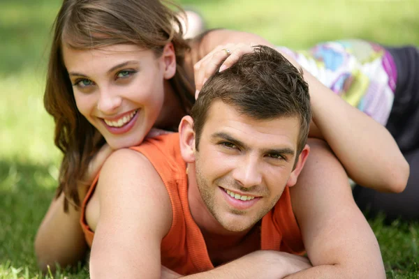 Young couple laying in the park — Stock Photo, Image