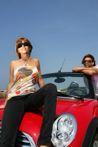Junges Paar lächelnd an ein Auto gelehnt — Stockfoto
