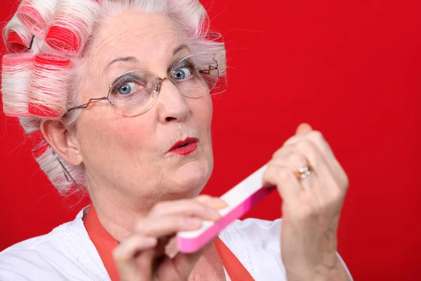 Elderly woman filing her nails Stock Image
