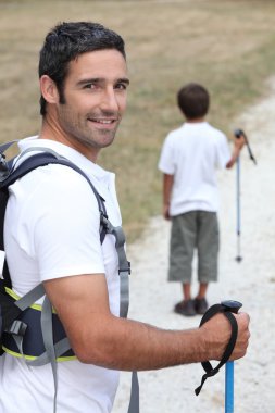 A father and his son hiking clipart