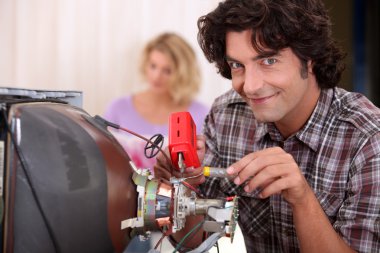 Man repairing television set clipart