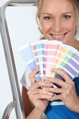 Female decorator with a selection of color swatches clipart