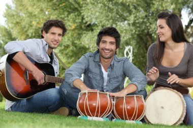 Three young musicians in park clipart