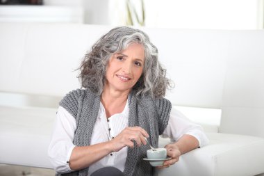 Woman sitting on the floor with a cup of coffee clipart