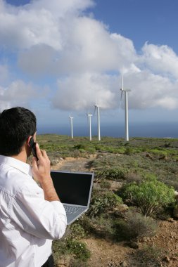 Man taking reading from wind farm clipart