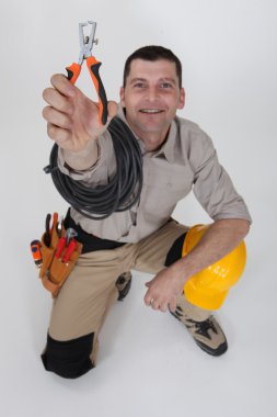 An electrician holding a wire stripper. clipart