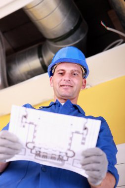 Engineer with a heating plan clipart