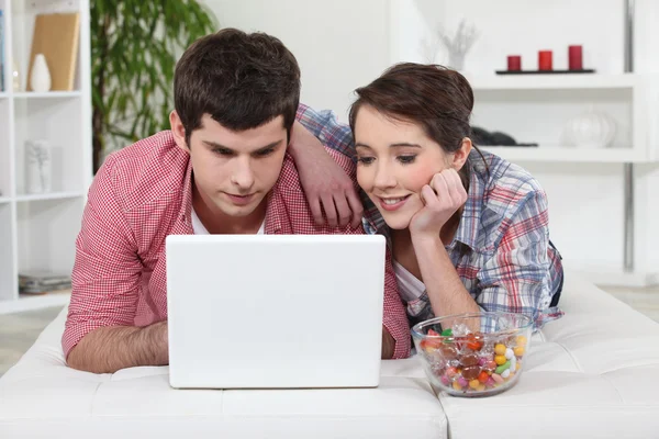 Jovem casal assistindo um filme em seu laptop — Fotografia de Stock