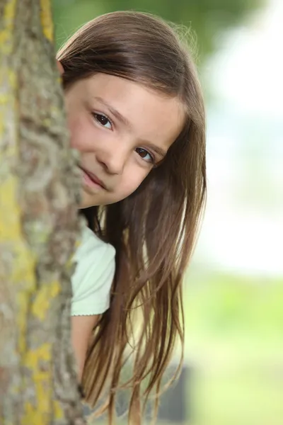 Menina atrás de uma árvore — Fotografia de Stock
