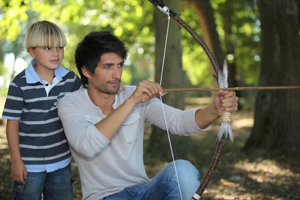 Jovem com arqueiro e criança — Fotografia de Stock