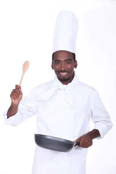 Chef with a pan and wooden spoon — Stock Photo, Image