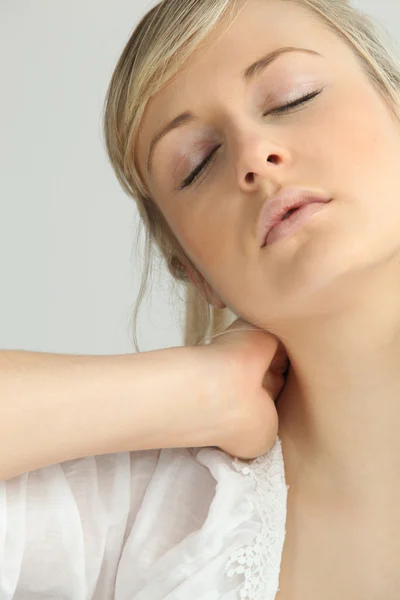 Chica rubia con dolor de cuello —  Fotos de Stock