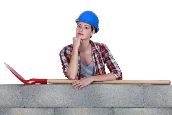 Woman with spade stood by wall — Stock Photo, Image