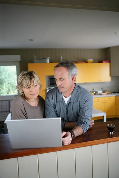 Paar met laptop in de keuken — Stockfoto