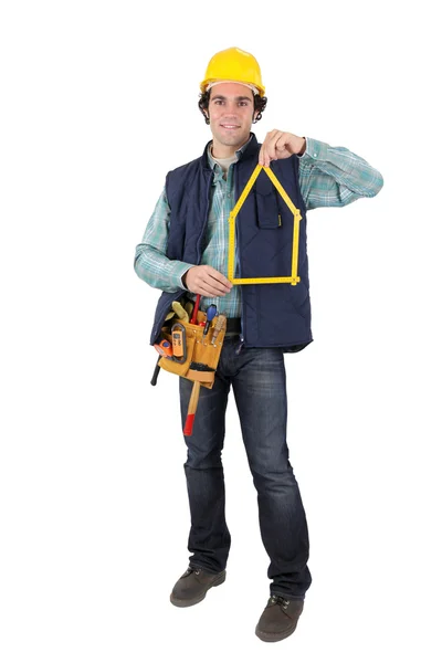 Homem segurando ferramenta em forma de casa — Fotografia de Stock