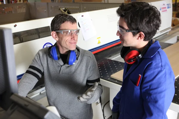 Handwerker und Lehrling arbeiten gemeinsam in einer Fabrik — Stockfoto