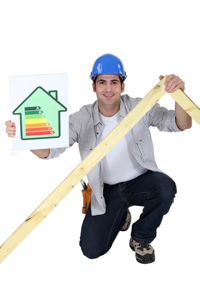 Comerciante sosteniendo un marco y una tabla de calificación de eficiencia energética — Foto de Stock