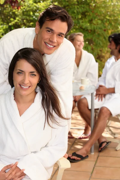Met vrienden op een terras in de handdoek gewaden zitten (echt) paar — Stockfoto