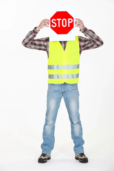 Builder covering face with stop sign — Stock Photo, Image