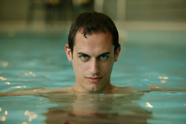 Mladý muž koupající se v bazénu — Stock fotografie