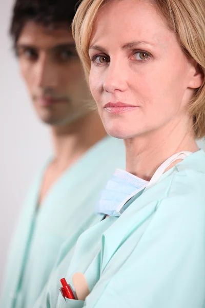 Enfermera rubia de pie con colega varón — Foto de Stock