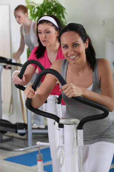 Femmina utilizzando una macchina da ginnastica in palestra — Foto Stock