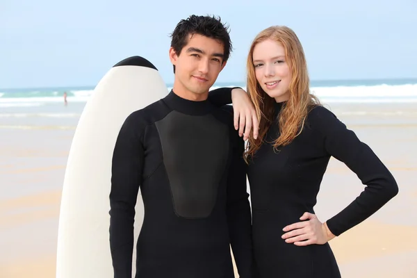 Surfing couple in wetsuits — Stock Photo, Image