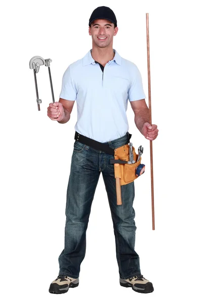Plumber holding pipe and bending tool — Stock Photo, Image