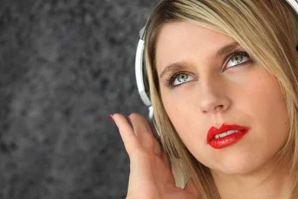Kvinna lyssnar på musik på hörlurar — Stockfoto