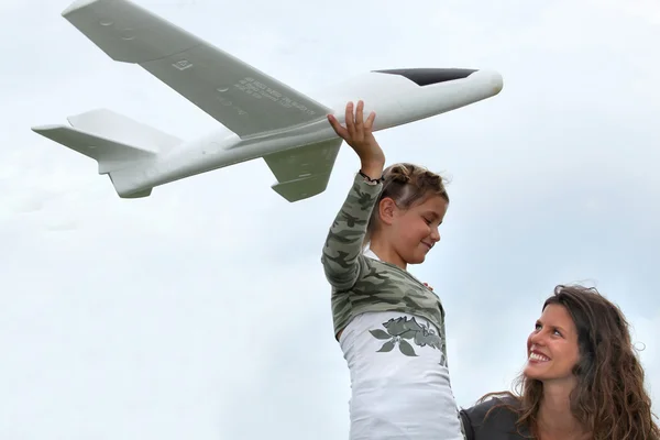 Menina brincando com um modelo de avião em pequena escala — Fotografia de Stock