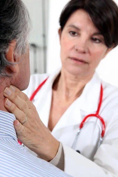 Doctor examining a senior patient — Stock Photo, Image