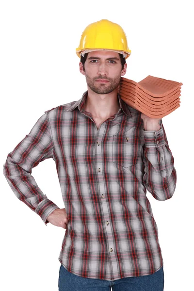 Construtor segurando pilha de telhas — Fotografia de Stock