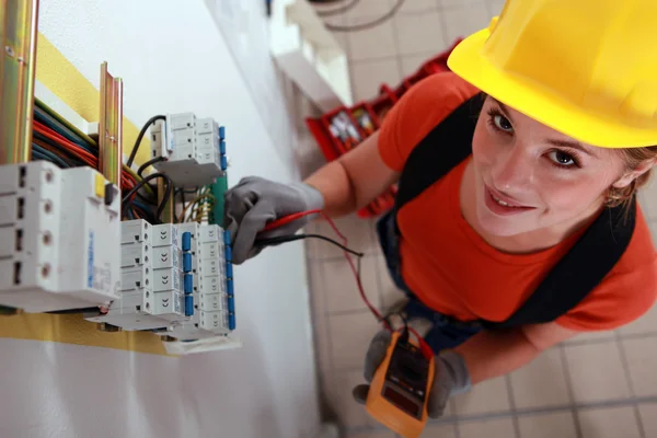 Kvinnliga elektriker kontrollera säkringsdosan — Stockfoto