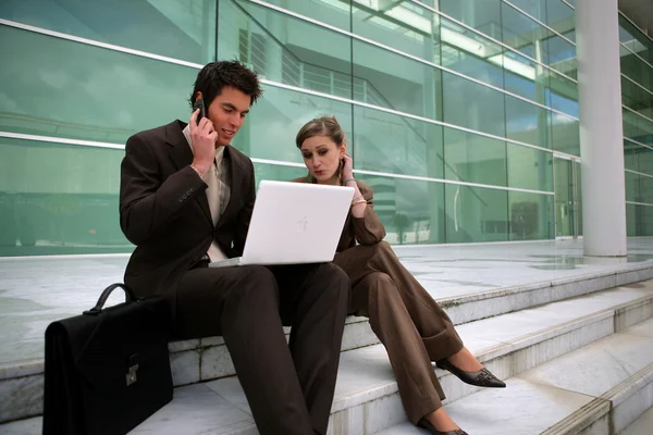 Young business couple sat on steps — Stock Photo, Image