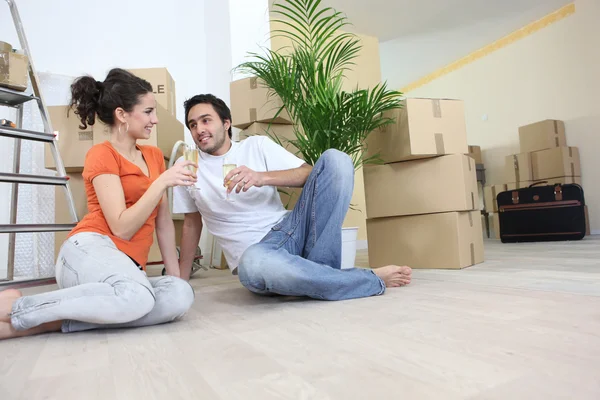Couple moving in to flat drinking champagne — Stock Photo, Image