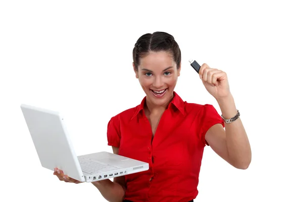 Счастливая женщина с USB-ключом и ноутбуком — стоковое фото
