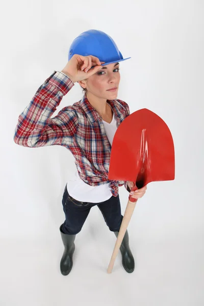 Craftswoman holding a shovel and making a helmet tip — Stock Photo, Image