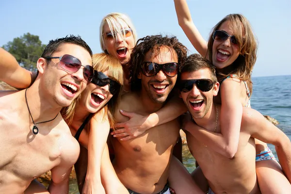Grupp av unga vuxna festandet på stranden — Stockfoto
