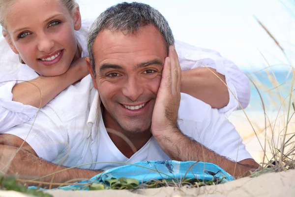 Couple laid on towel at the beach Stock Photo