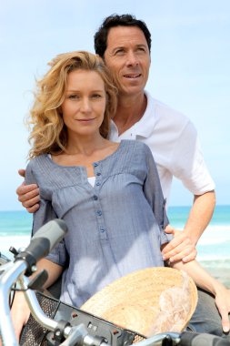 Couple with bike by the sea clipart